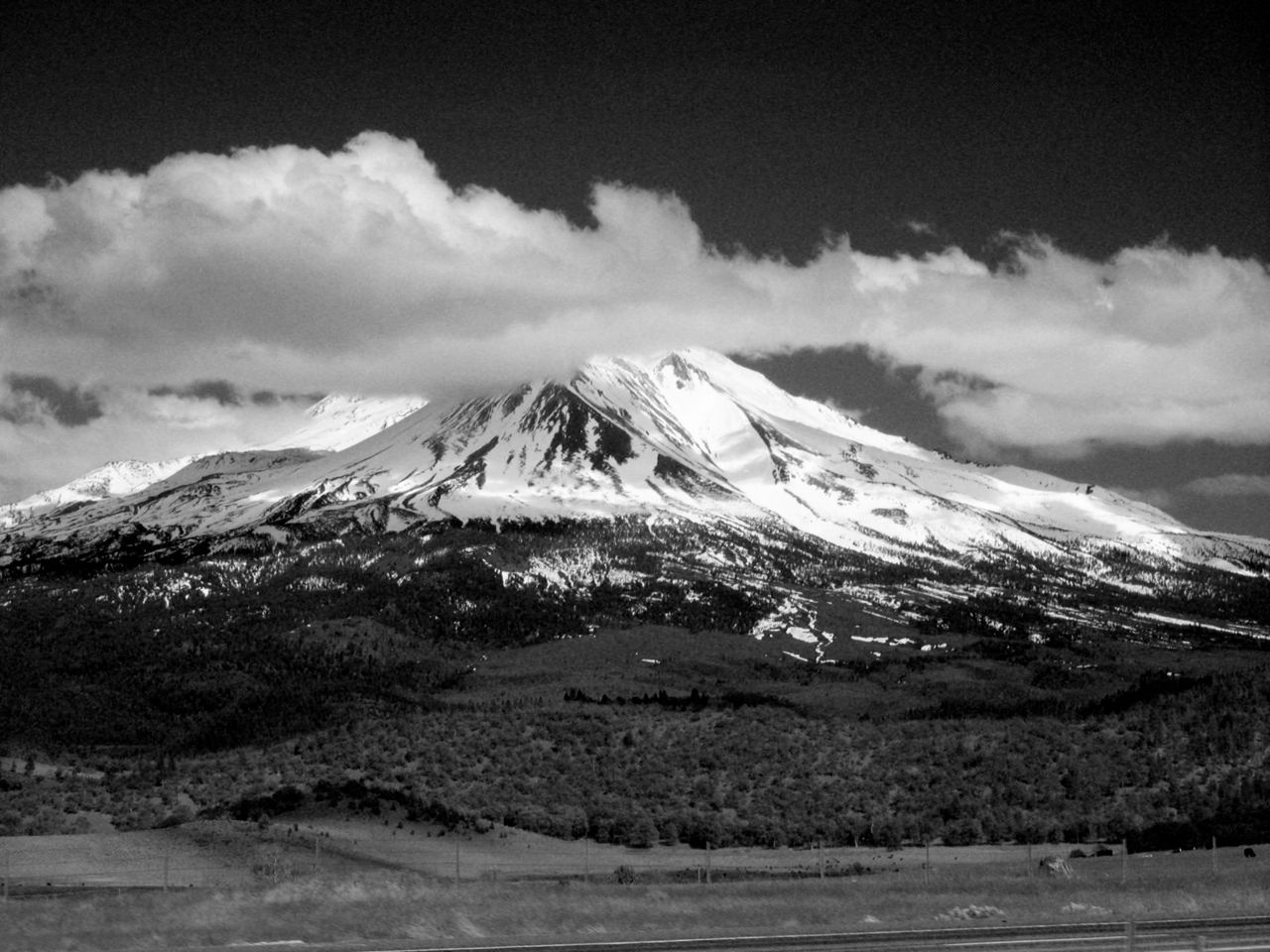 Black and white photo of Mount Shasta in California, showcasing its dramatic snow-capped peak.